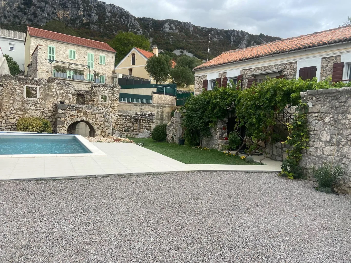 The pool, the ruin and the house across the gravel courtyard