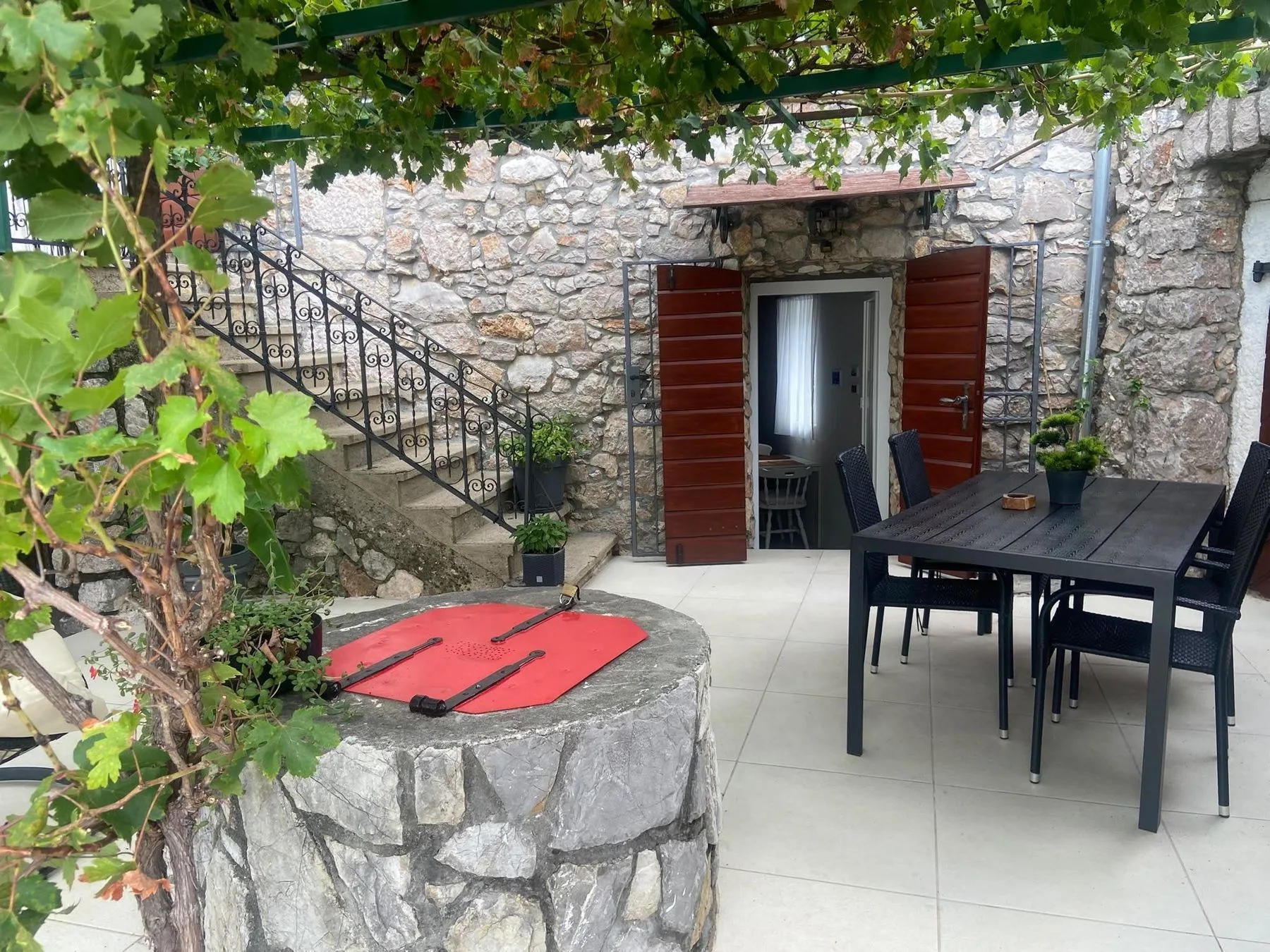 The terrace under the vine: the table, the door and the outside stairs