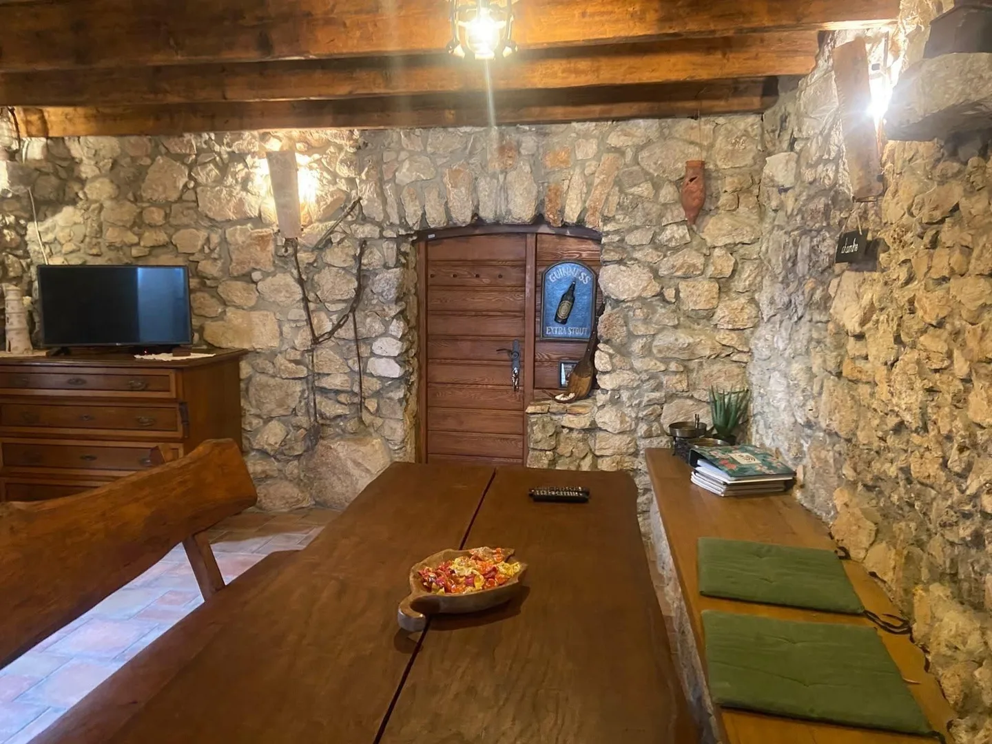 The long wooden table and benches under the beams