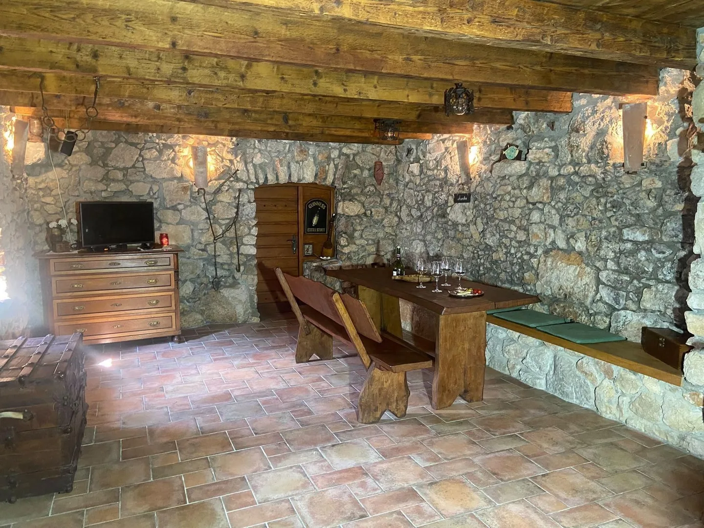 The konoba from the far end: terracotta floor and stone walls