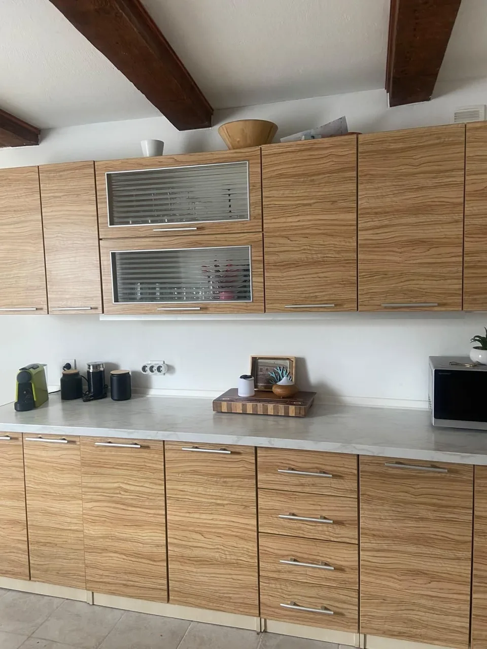 The kitchen: wood-grain cabinets under the ceiling beams