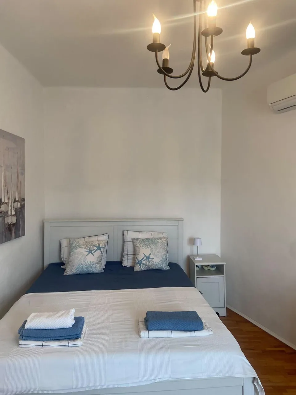 The white bed under a chandelier