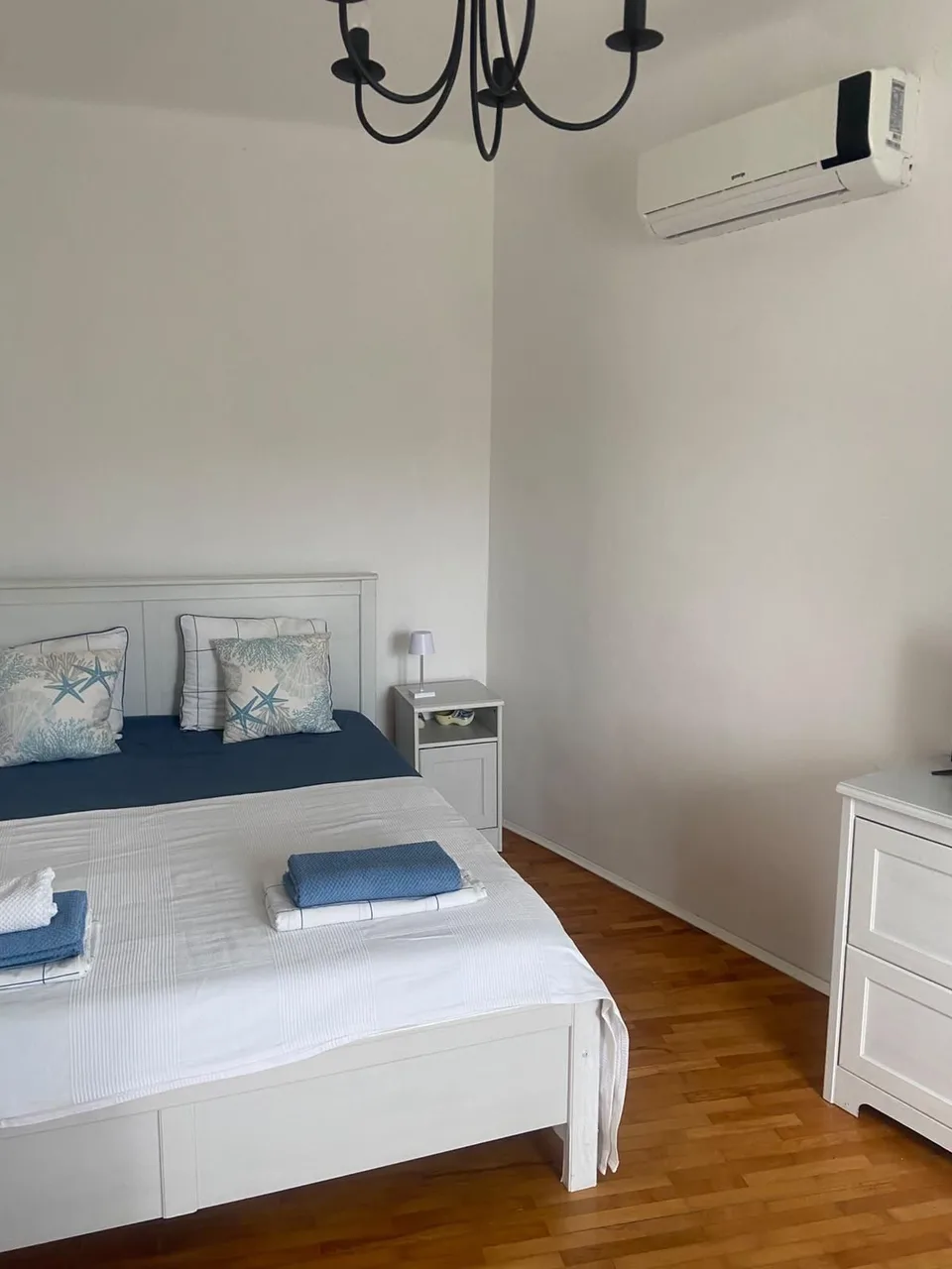 The bed and a white chest of drawers