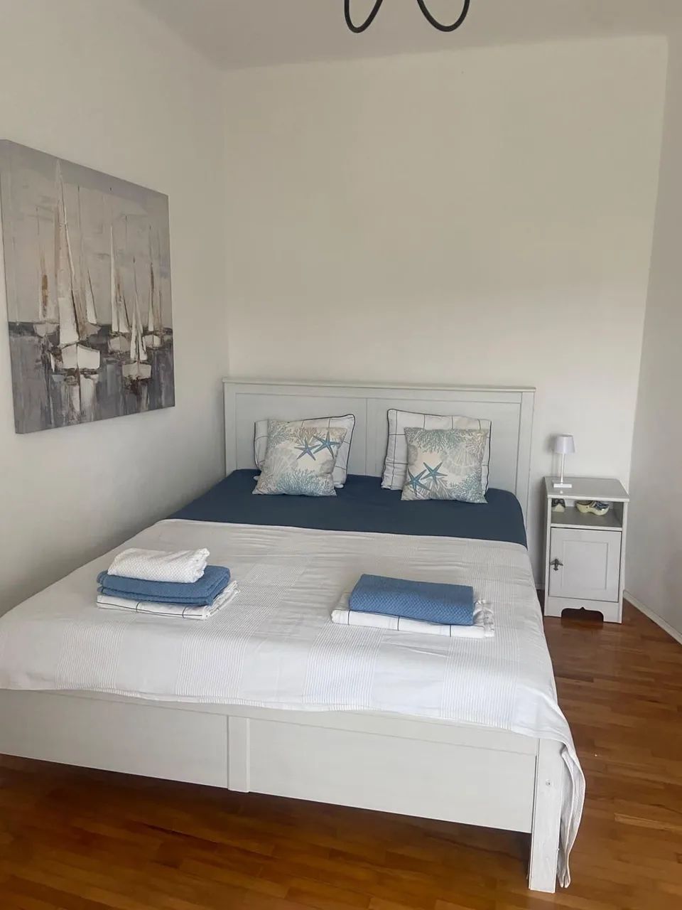 The white bedroom: a double bed and a painting of sailing boats