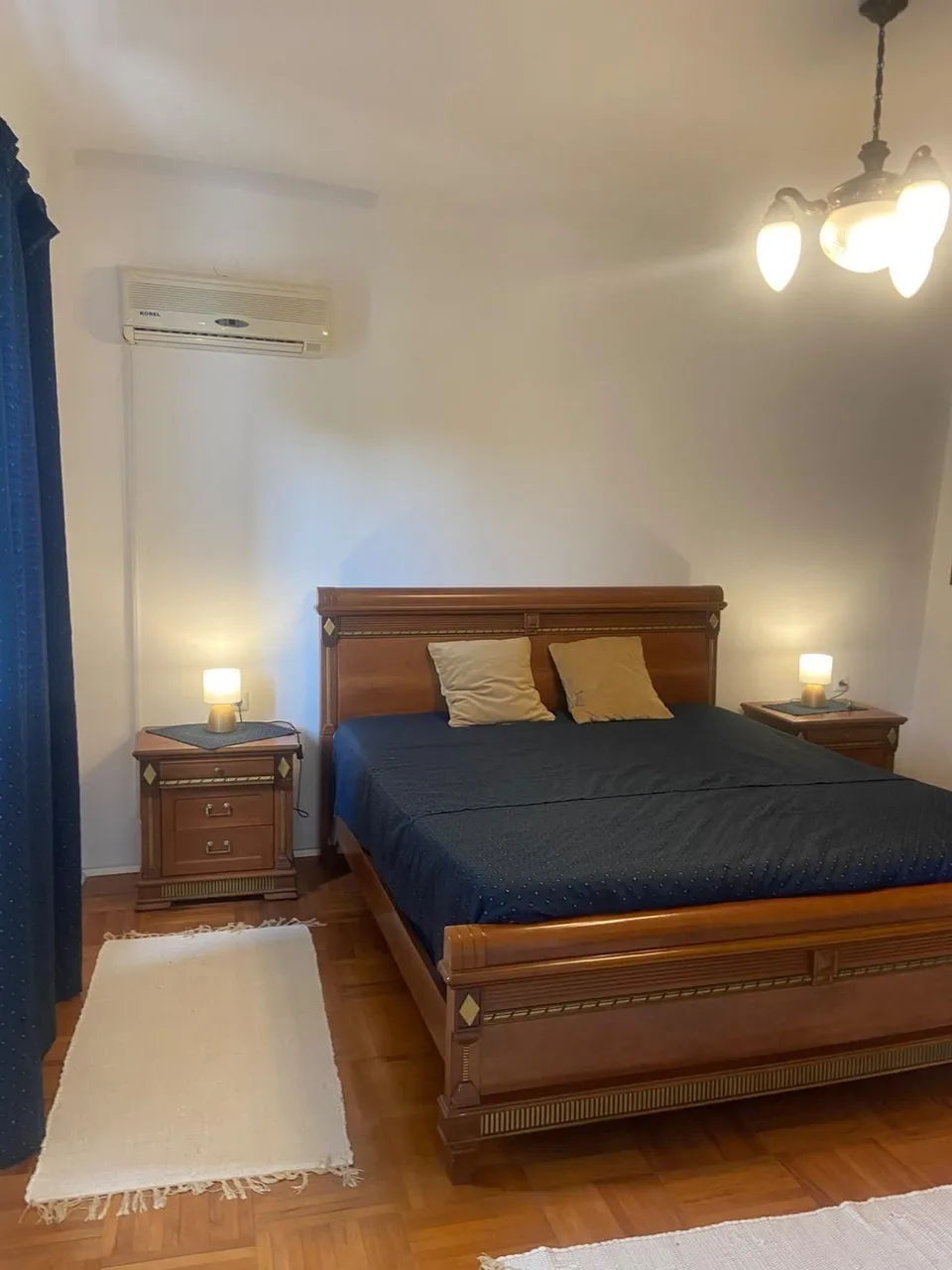 The double bed with bedside lamps, the air conditioning above