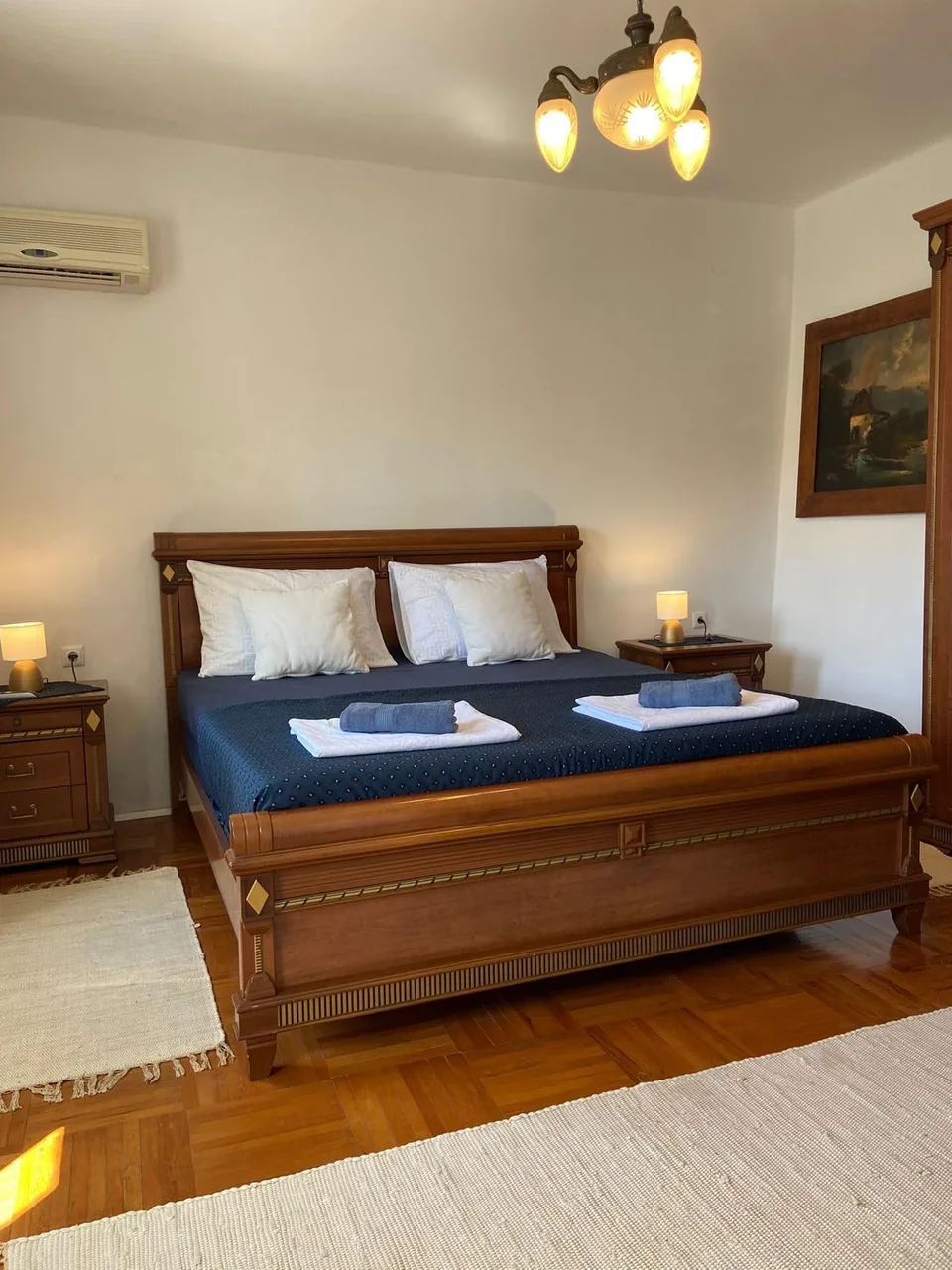 The bed made up with towels, a painting on the wall
