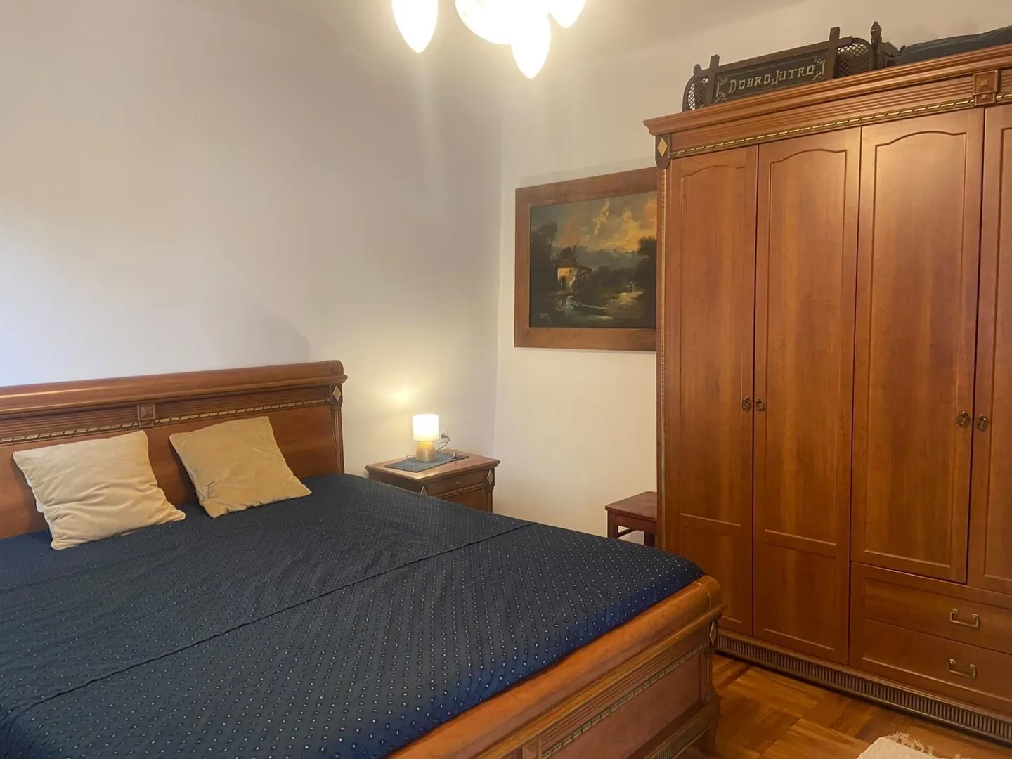 The dark-wood bedroom: a double bed and a tall wardrobe