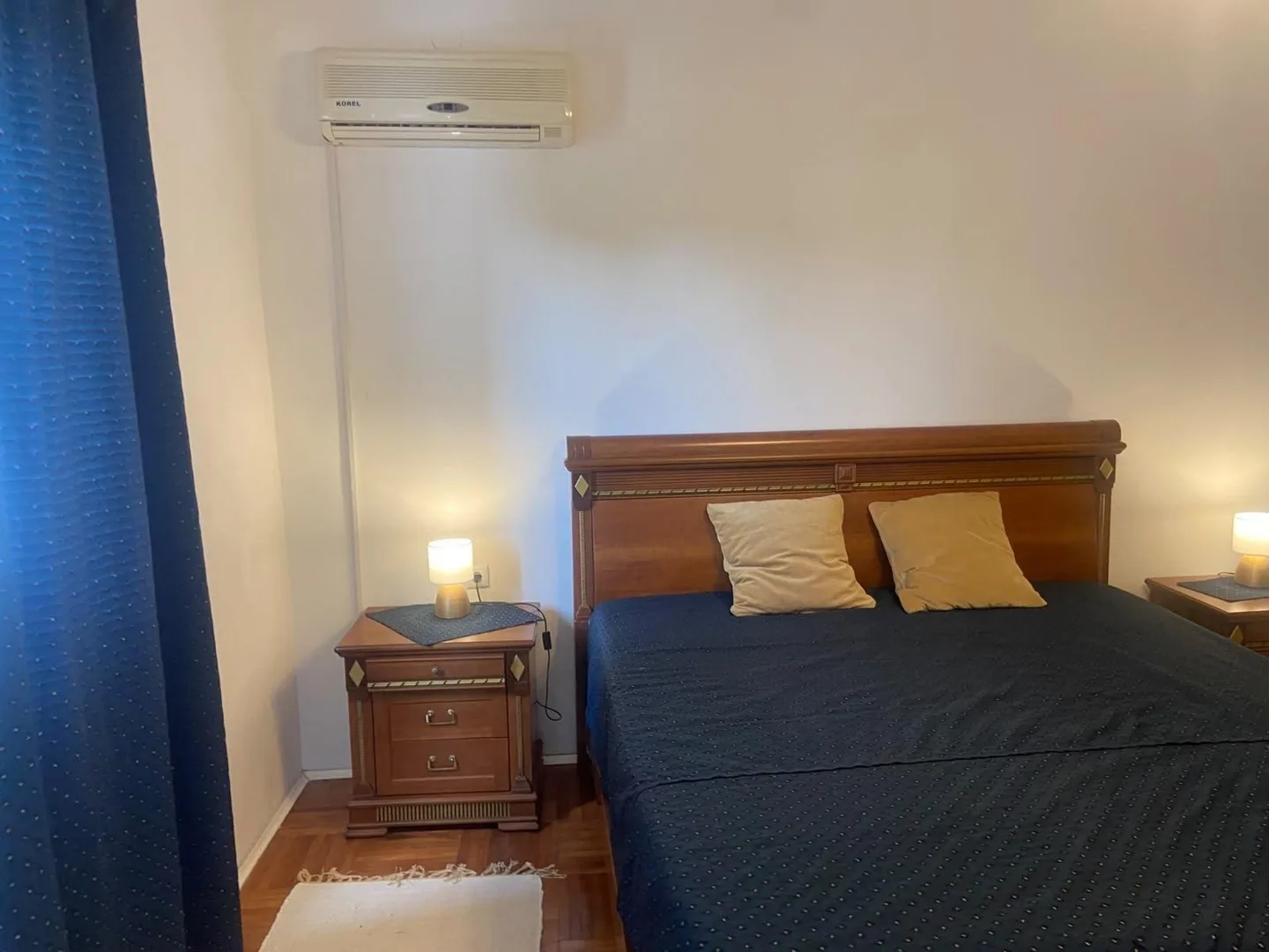 The bed by lamplight, a blue curtain in front