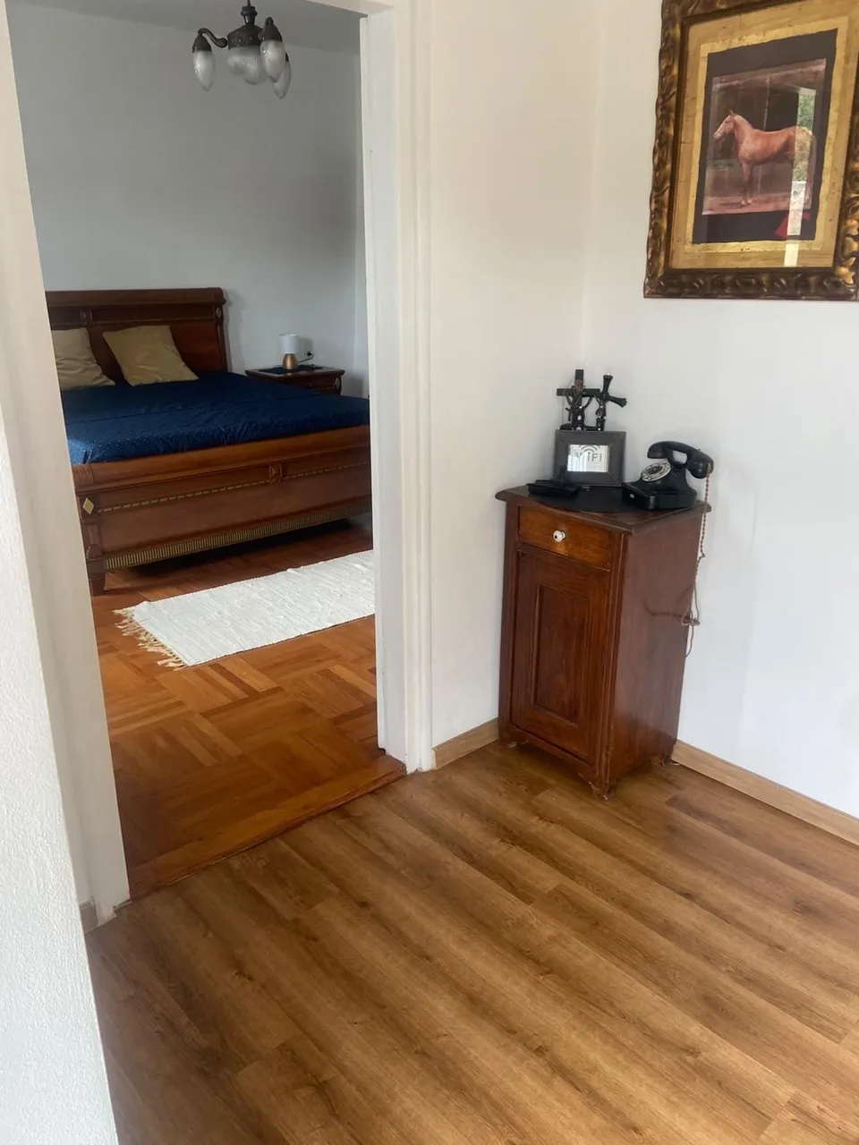 The hallway, a door open to the dark-wood bedroom